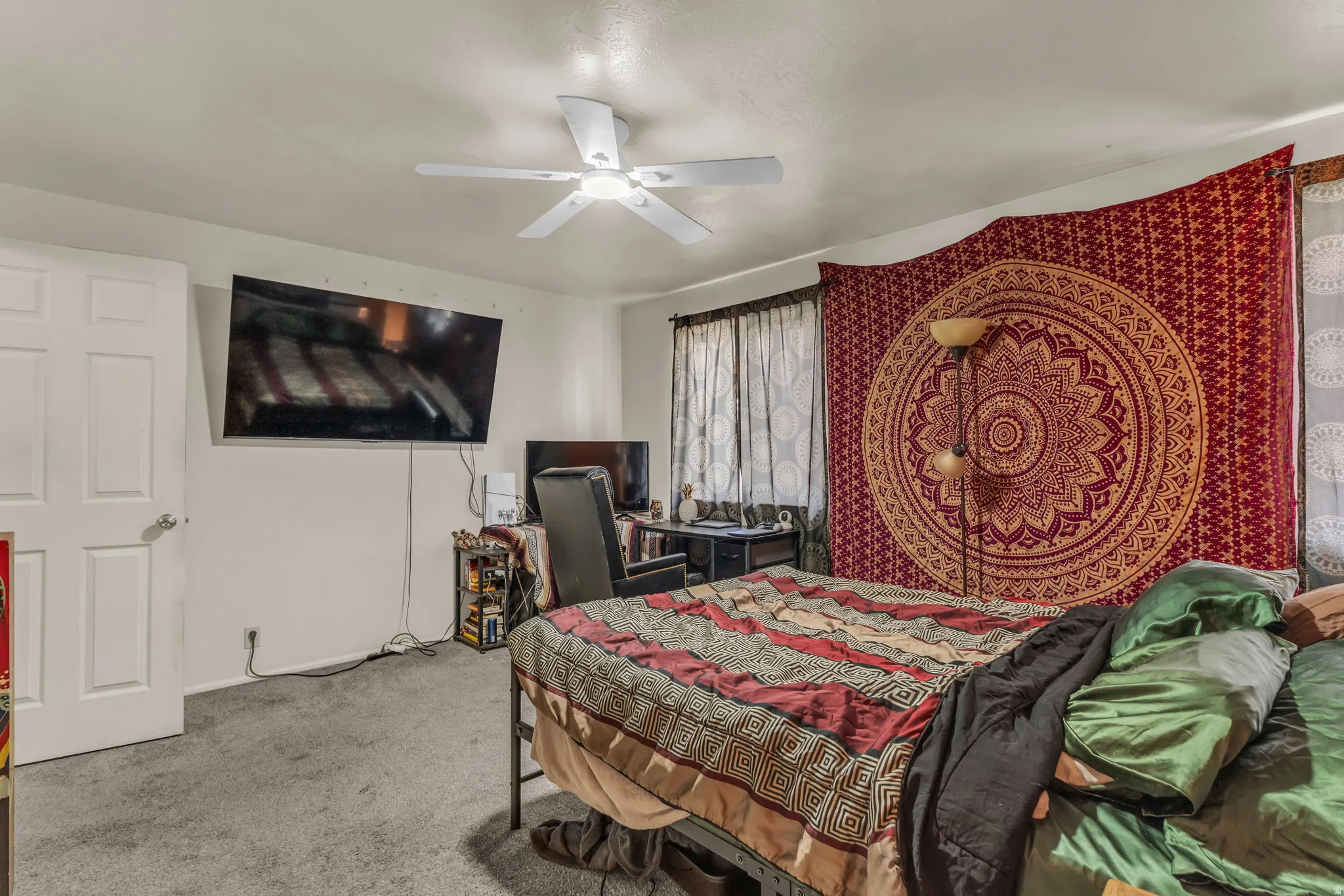Carpeted room with a white ceiling fan and light-toned walls