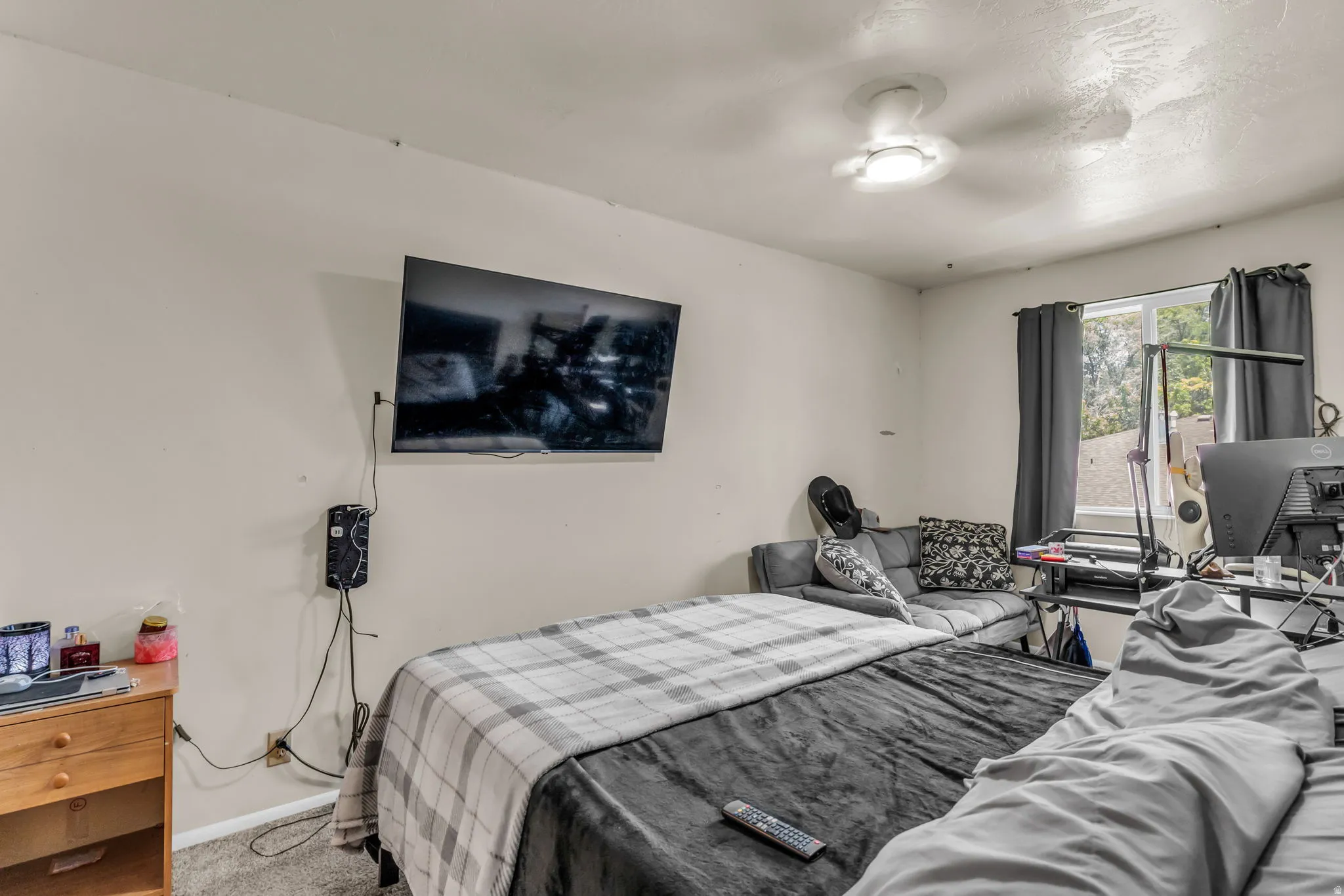 Room featuring light-toned walls, a ceiling-mounted light fixture, and a window with dark drapery