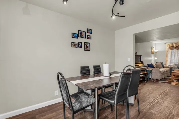 Dining area featuring wood-finish flooring, a neutral wall color, and track lighting