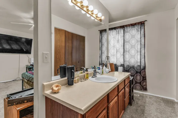 Bathroom vanity featuring an integrated sink, laminate countertop, and wood-finish cabinetry