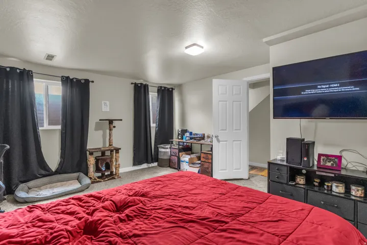 Carpeted room featuring multiple windows with dark curtains, a built-in wall niche, and an overhead flush-mount light fixture