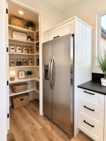 Walk-in pantry featuring white built-in shelving and recessed lighting