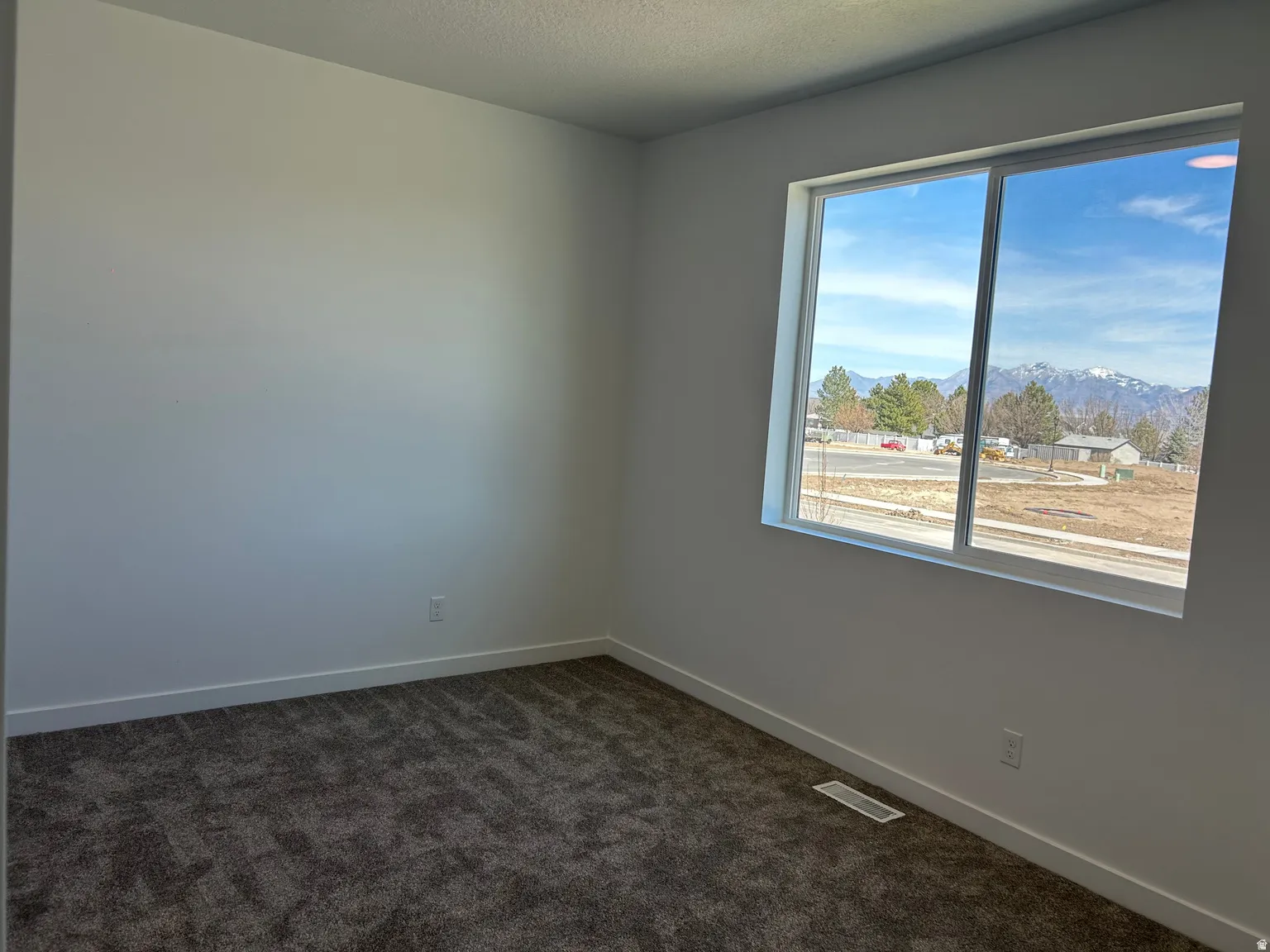 Crisp white walls frame a window with mountain scenery