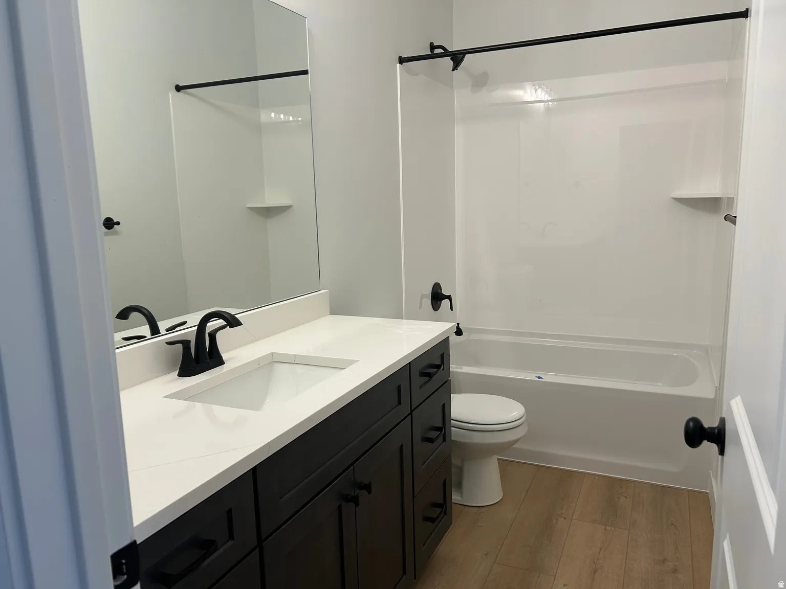 Bathroom featuring a single vanity with dark wood-finish cabinetry, a white countertop, and a rectangular undermount sink