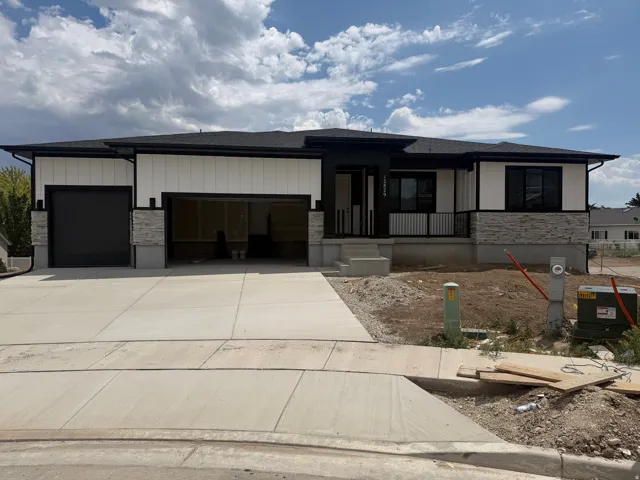 Contemporary single-story residence featuring a black and white exterior with stone accents