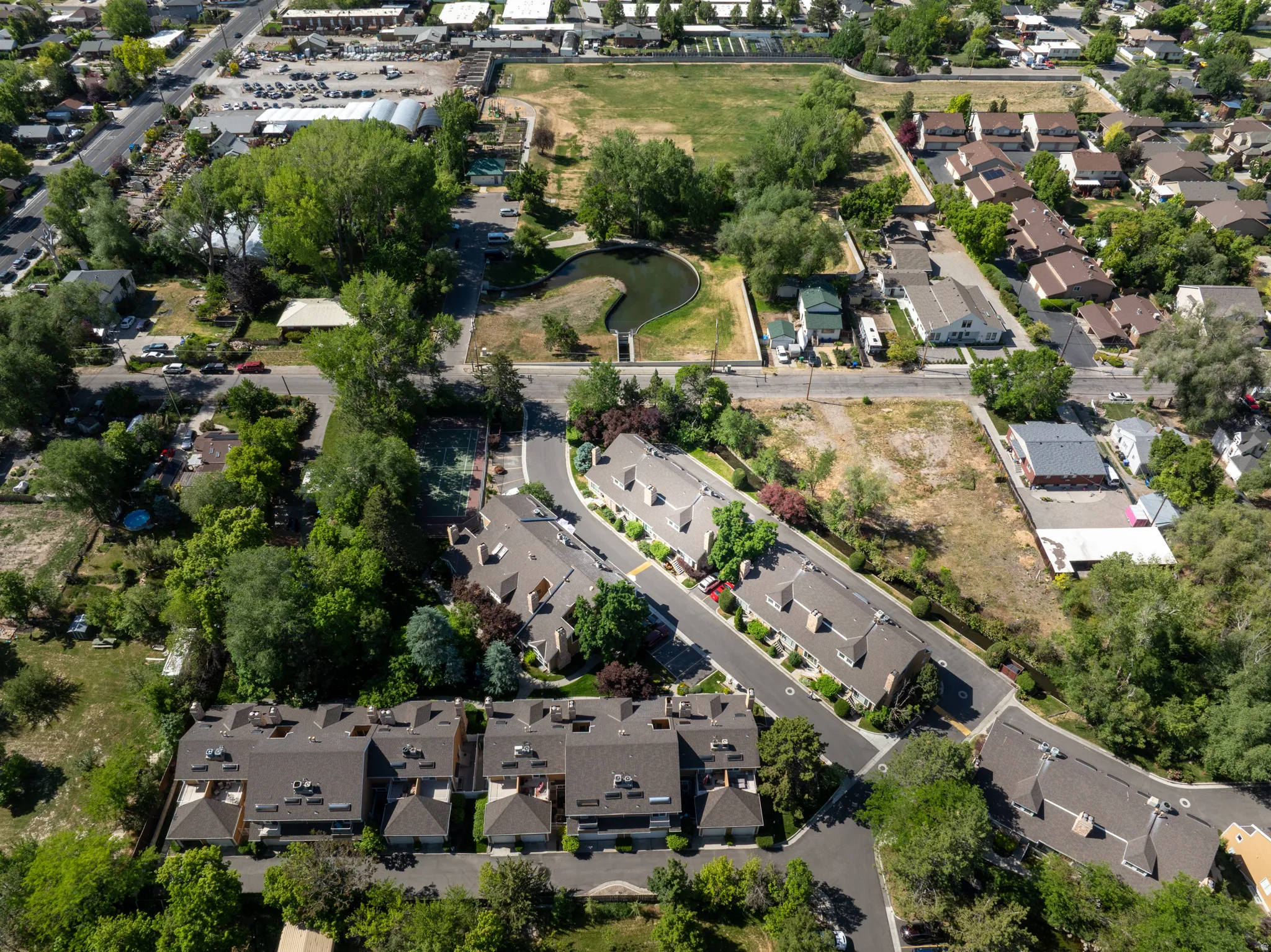 Aerial view showcasing a residential community with townhomes and detached properties