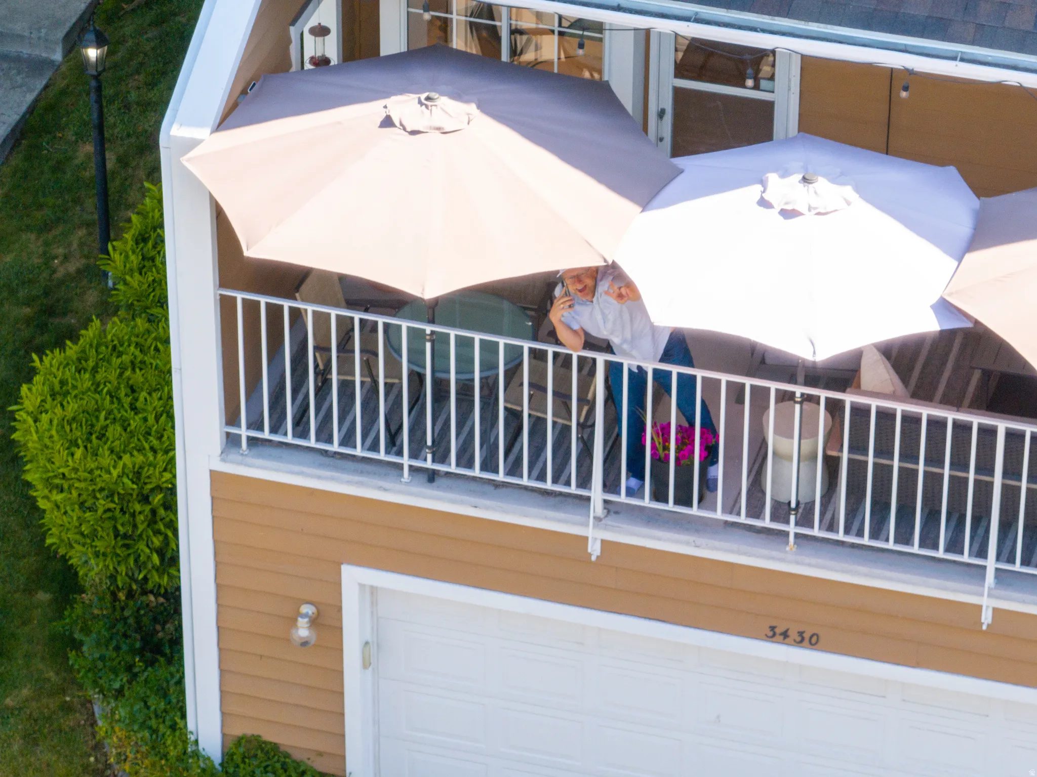 Upper-level balcony featuring white railings and a sliding glass door entry