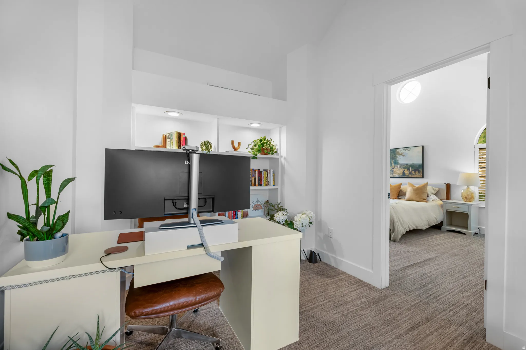 Dedicated office space featuring built-in shelving with recessed lighting, vaulted ceilings, and plush carpet flooring