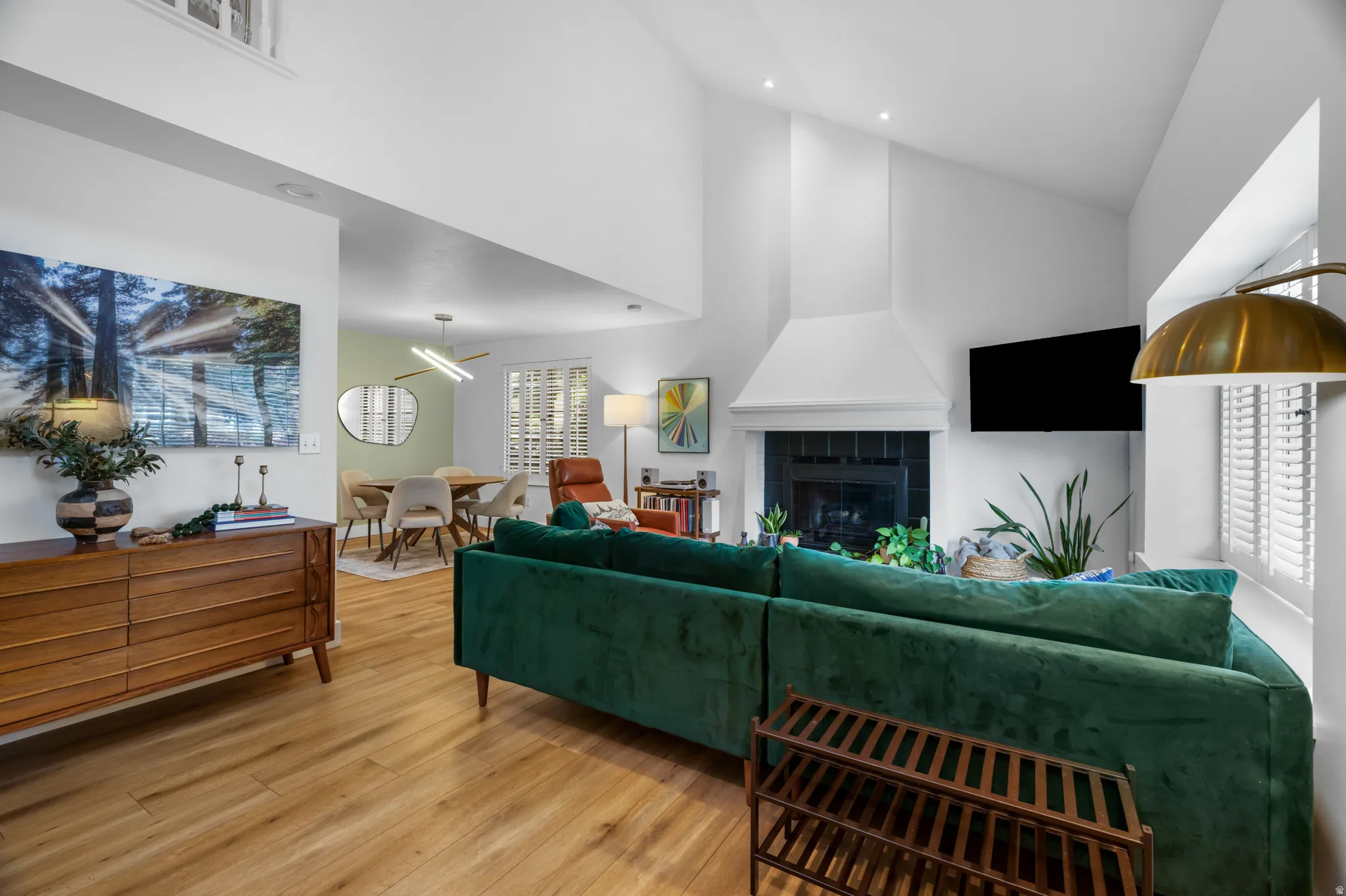 Vaulted ceilings accentuate this open-concept living area with wood-finish flooring