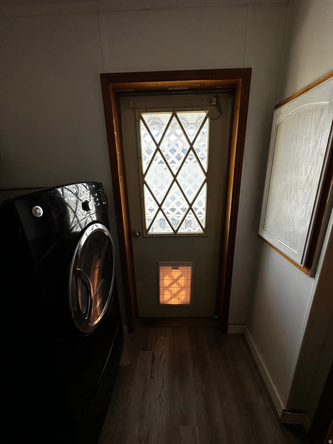 Entryway featuring a decorative glass door, wood-finish flooring, and white baseboards