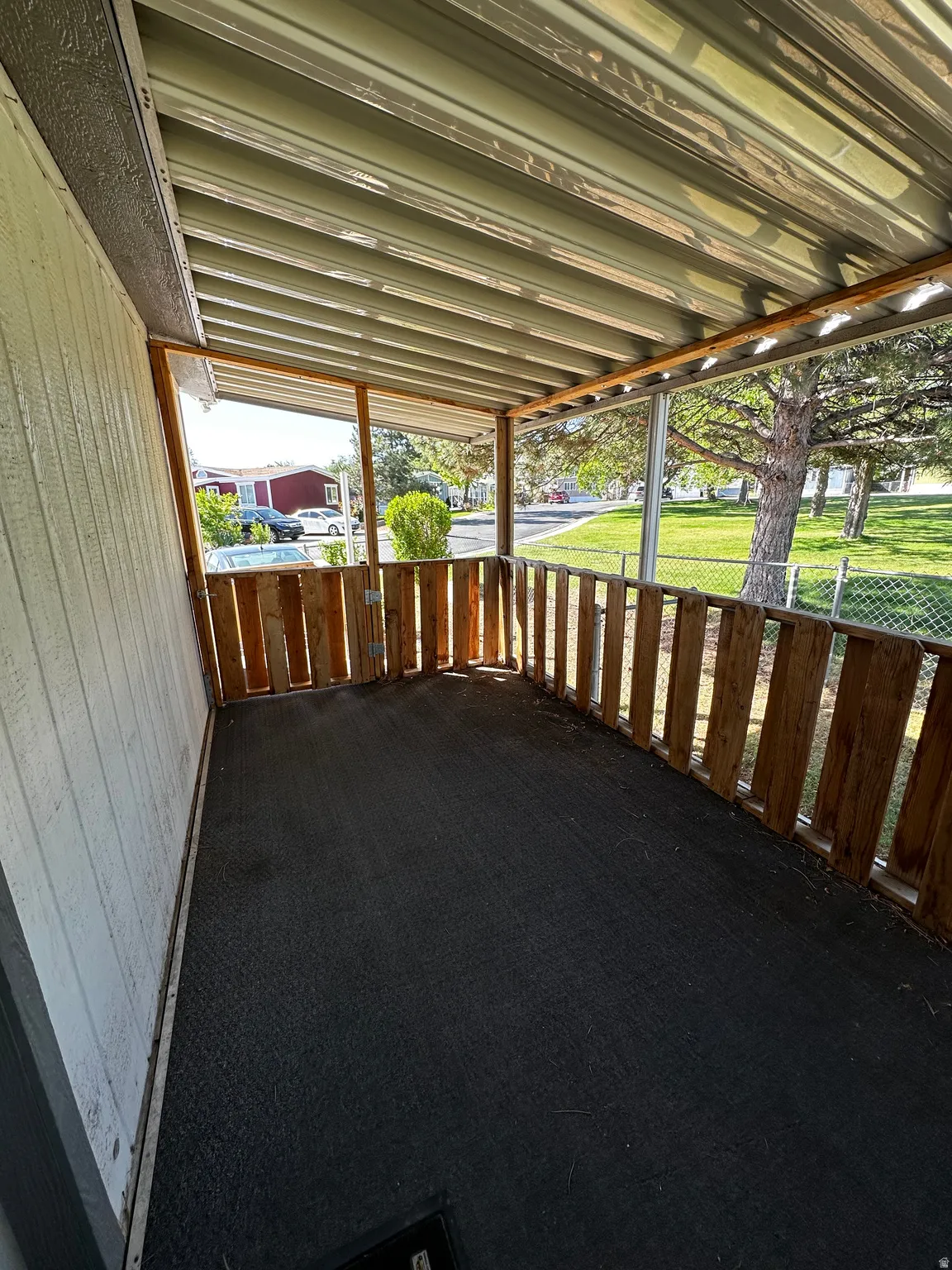 Covered porch featuring a corrugated metal roof and wood paneling