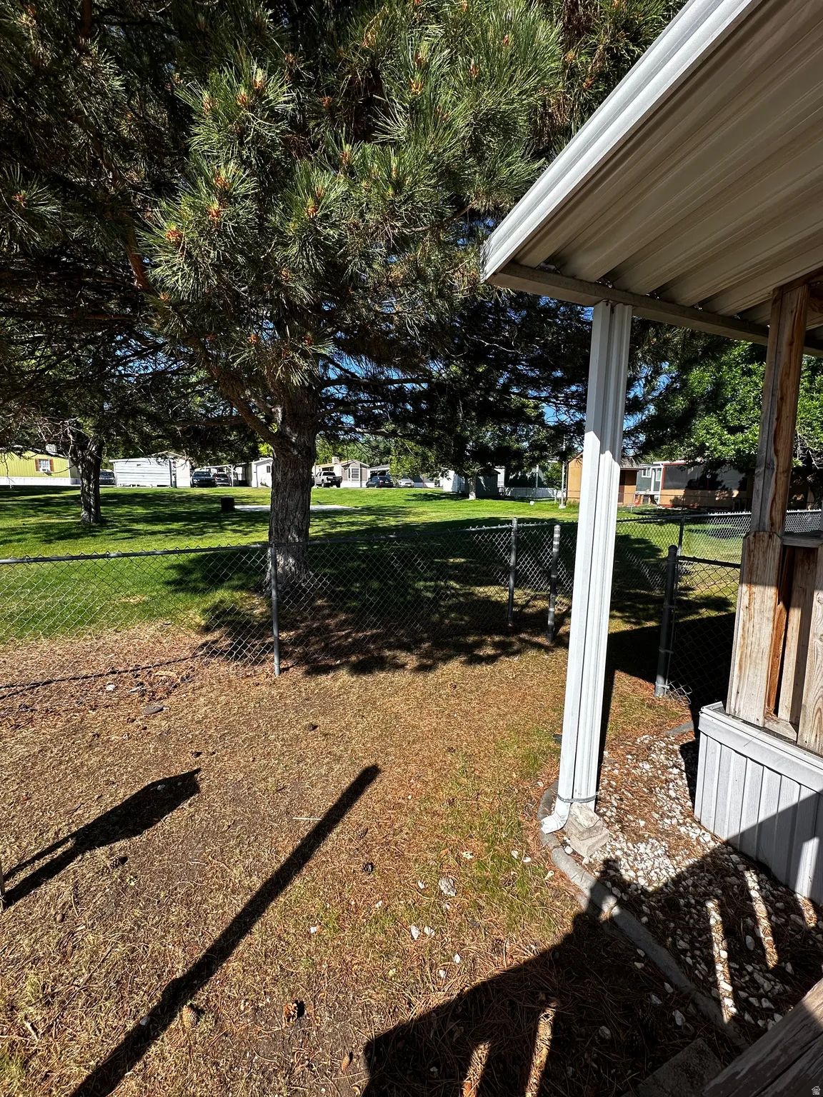 Covered porch entrance featuring a white support column and composite siding
