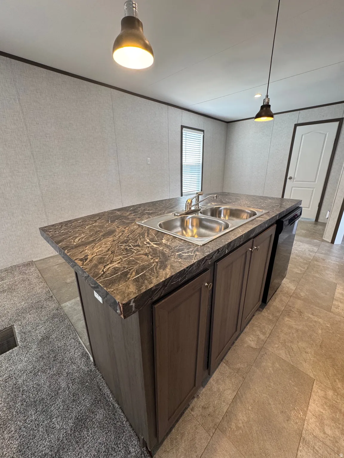 Kitchen island featuring a double basin sink with a chrome faucet