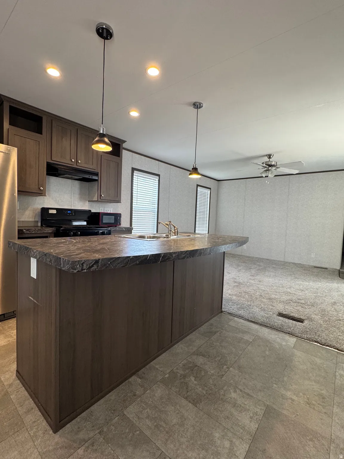Kitchen island with a dark wood-finish base and a stone-look countertop