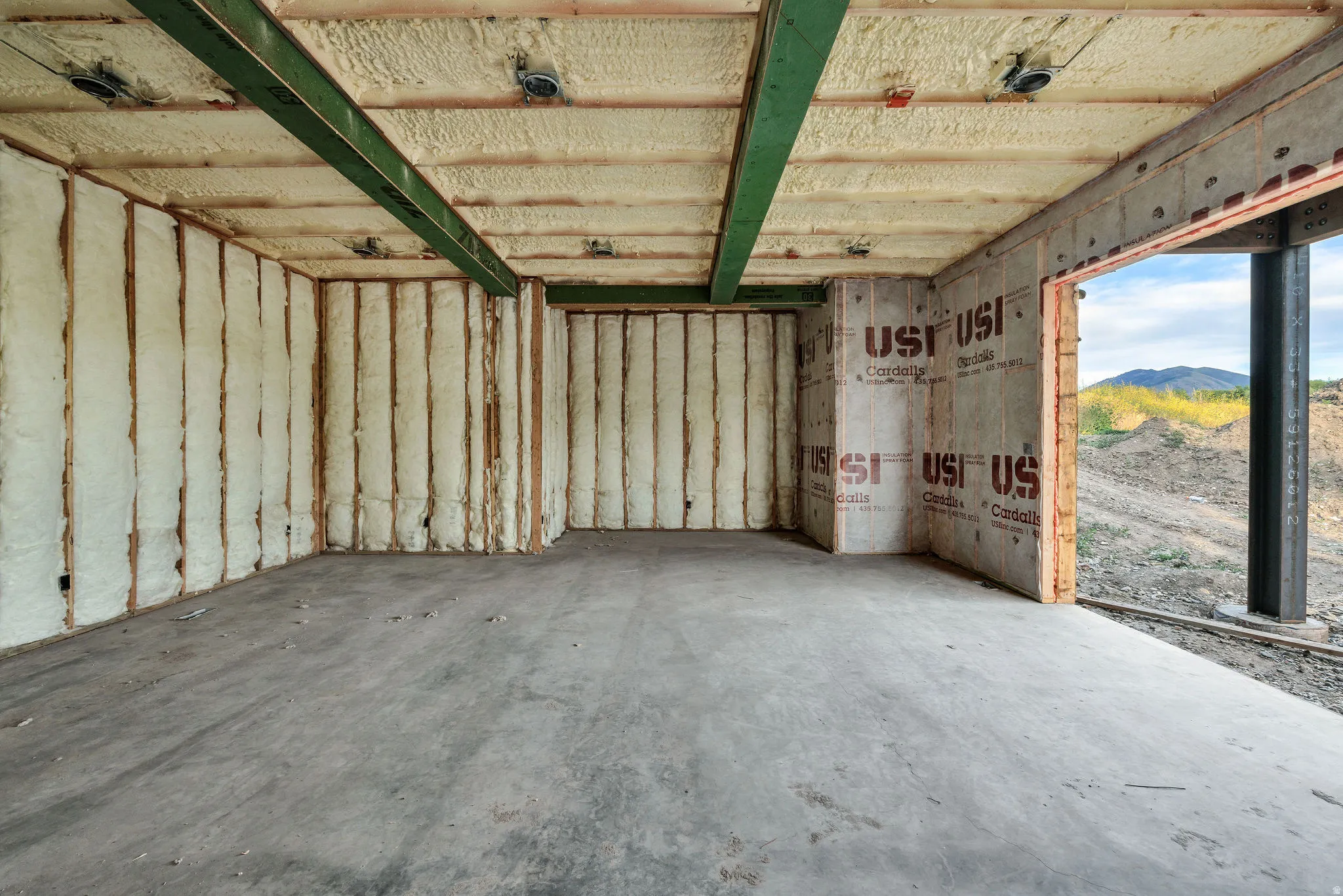 Unfinished interior space featuring exposed ceiling joists, spray foam insulation, and concrete flooring