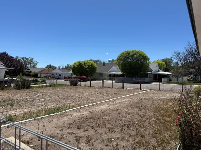 Expansive undeveloped lot featuring clear land and defined property lines, bordered by a wire fence