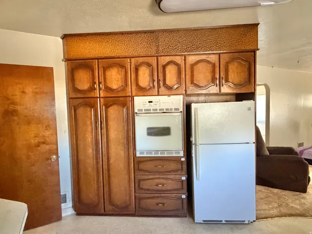 Wood-finish cabinetry with decorative trim and integrated wall oven