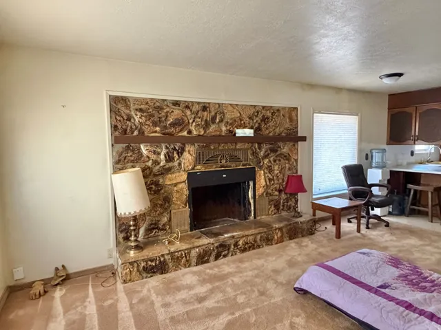 Stone-clad fireplace with a dark wood mantel and hearth