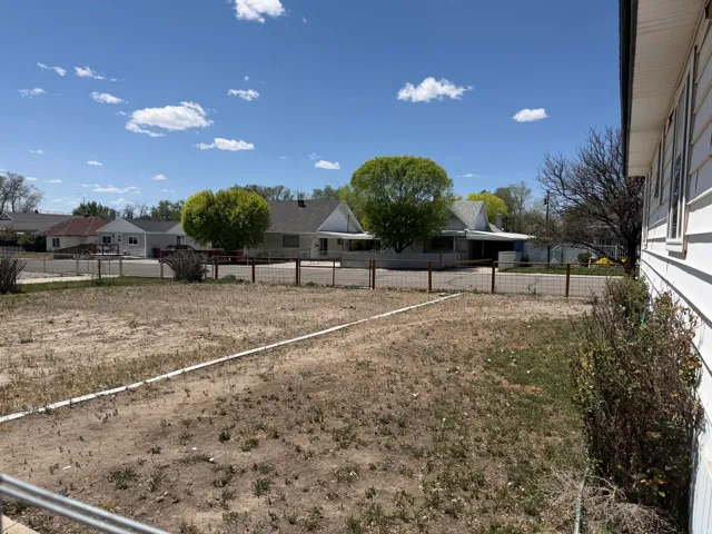 Spacious unlandscaped yard with metal fencing
