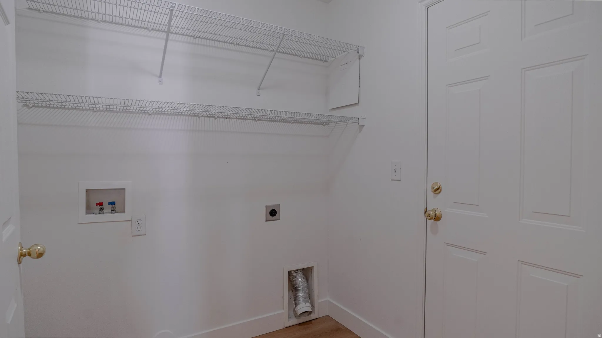 Dedicated laundry area featuring a white wire shelving system for storage