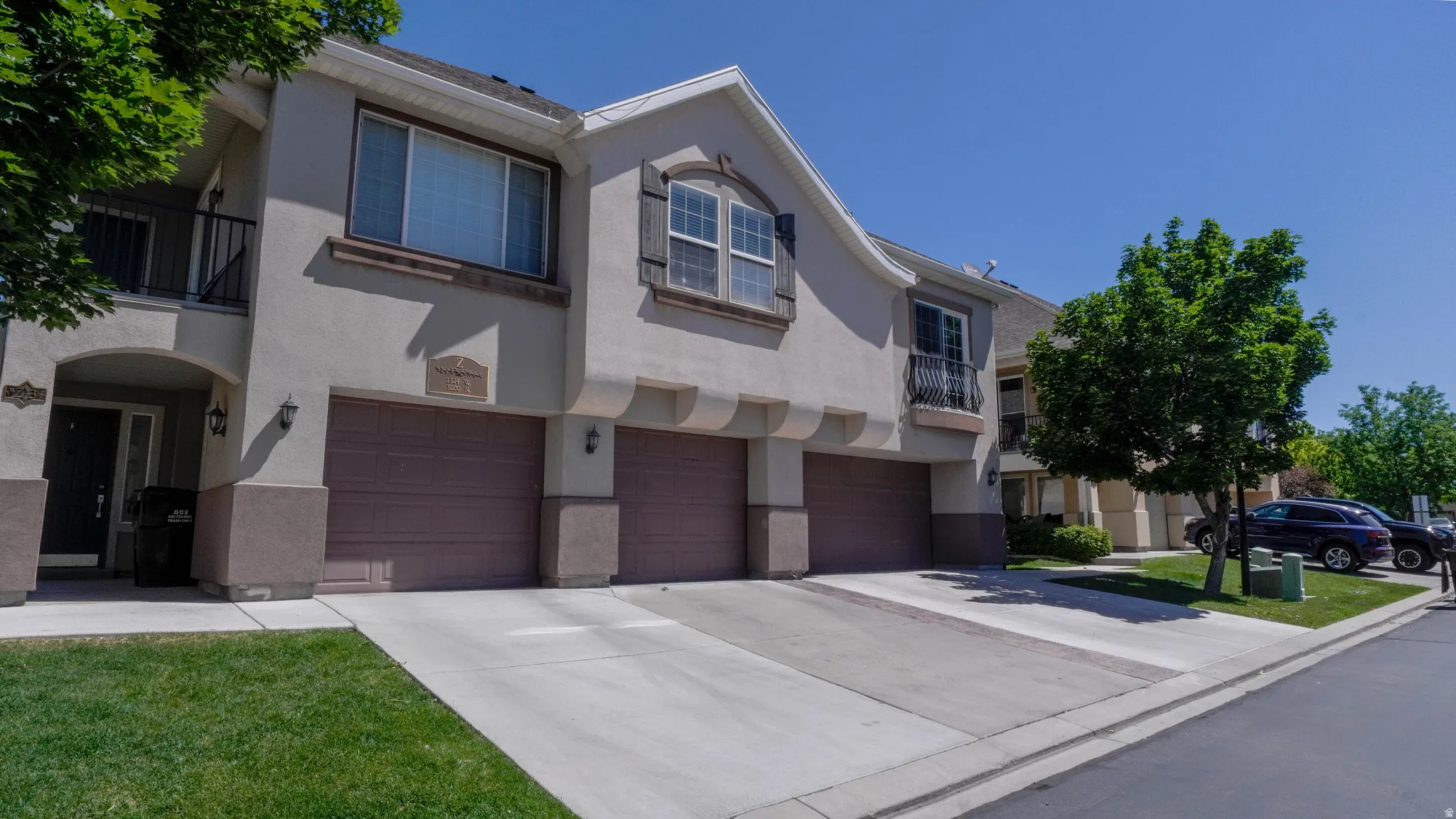 Multi-story stucco exterior featuring integrated garages with individual doors