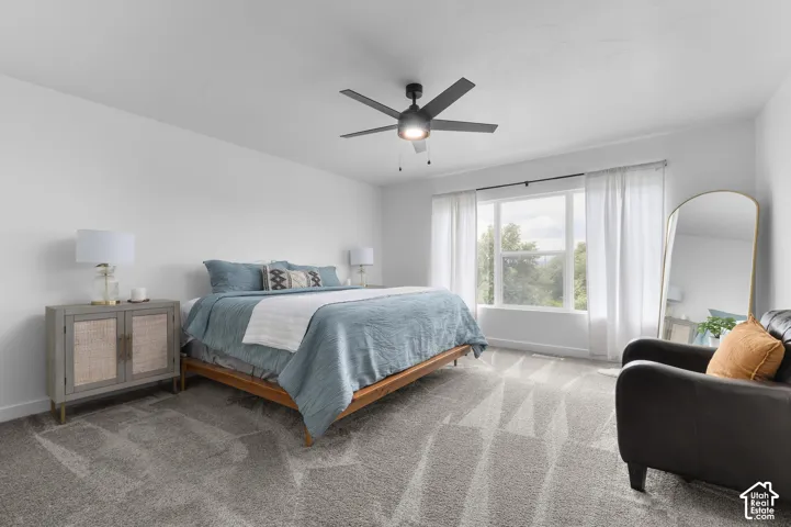 Spacious room featuring neutral carpeting, white walls, and a large window with ample natural light