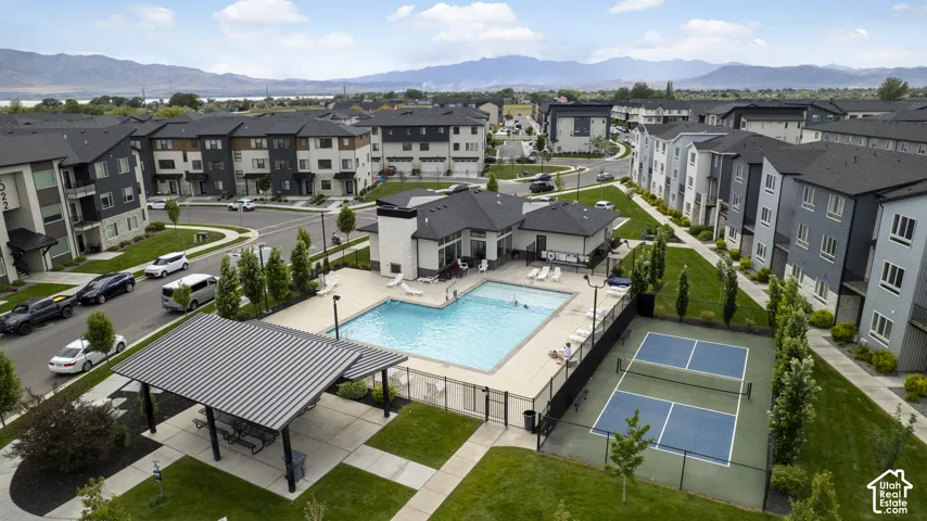 Community amenities featuring a swimming pool, covered outdoor seating area, and a pickleball court