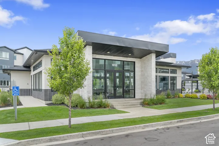 Modern building exterior featuring stone-finish siding, expansive glass storefront, and a prominent entry
