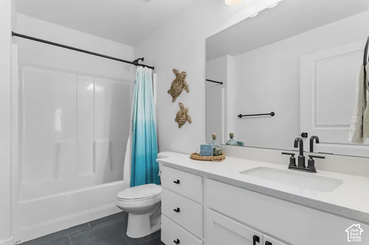Bathroom featuring a white vanity with a light-toned countertop, an integrated sink, and black fixtures