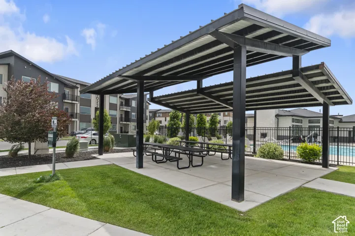 Outdoor shaded picnic area with multiple tables and concrete flooring