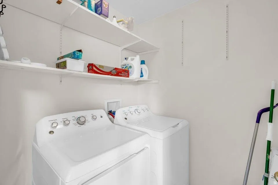 Dedicated laundry space featuring a white top-load washing machine and dryer