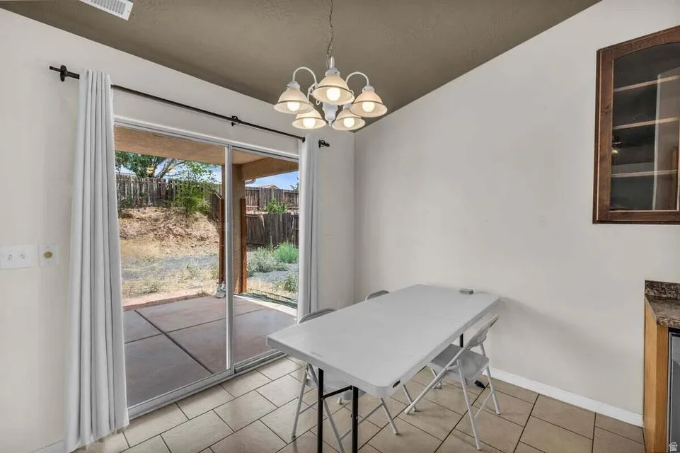 Dining area featuring a contemporary chandelier and tiled flooring