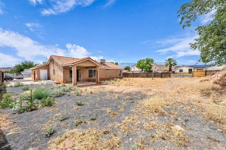 Rear exterior featuring a stucco finish, a covered patio with a concrete slab, and a terracotta tile roof