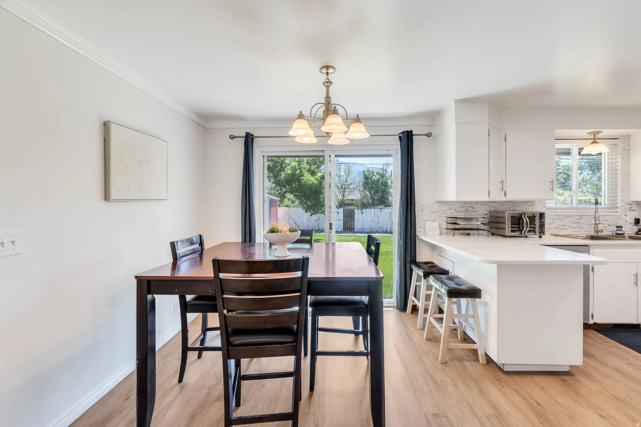 Semi formal dining area with wood-finish flooring and a brass-tone chandelier