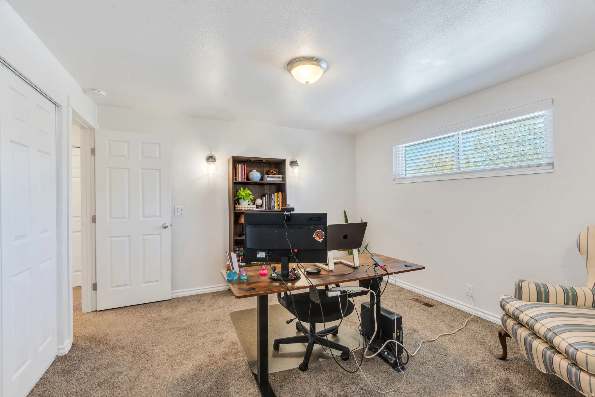Bedroom # / Office, carpeted room with horizontal window with blinds, sconce lighting and a ceiling-mounted light fixture
