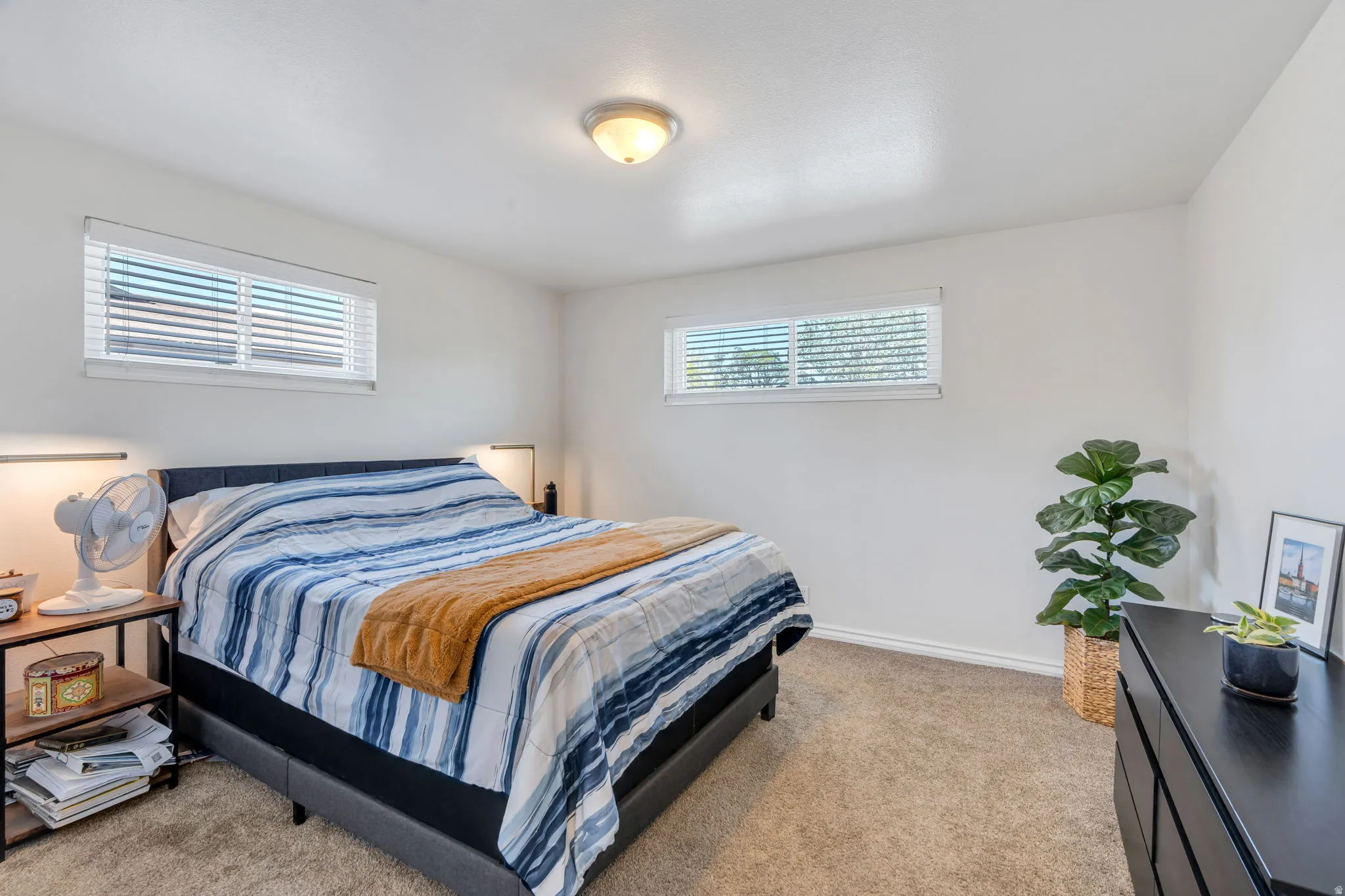 Bedroom #2 featuring neutral carpeting, white walls, two windows with blinds and a ceiling-mounted light fixture