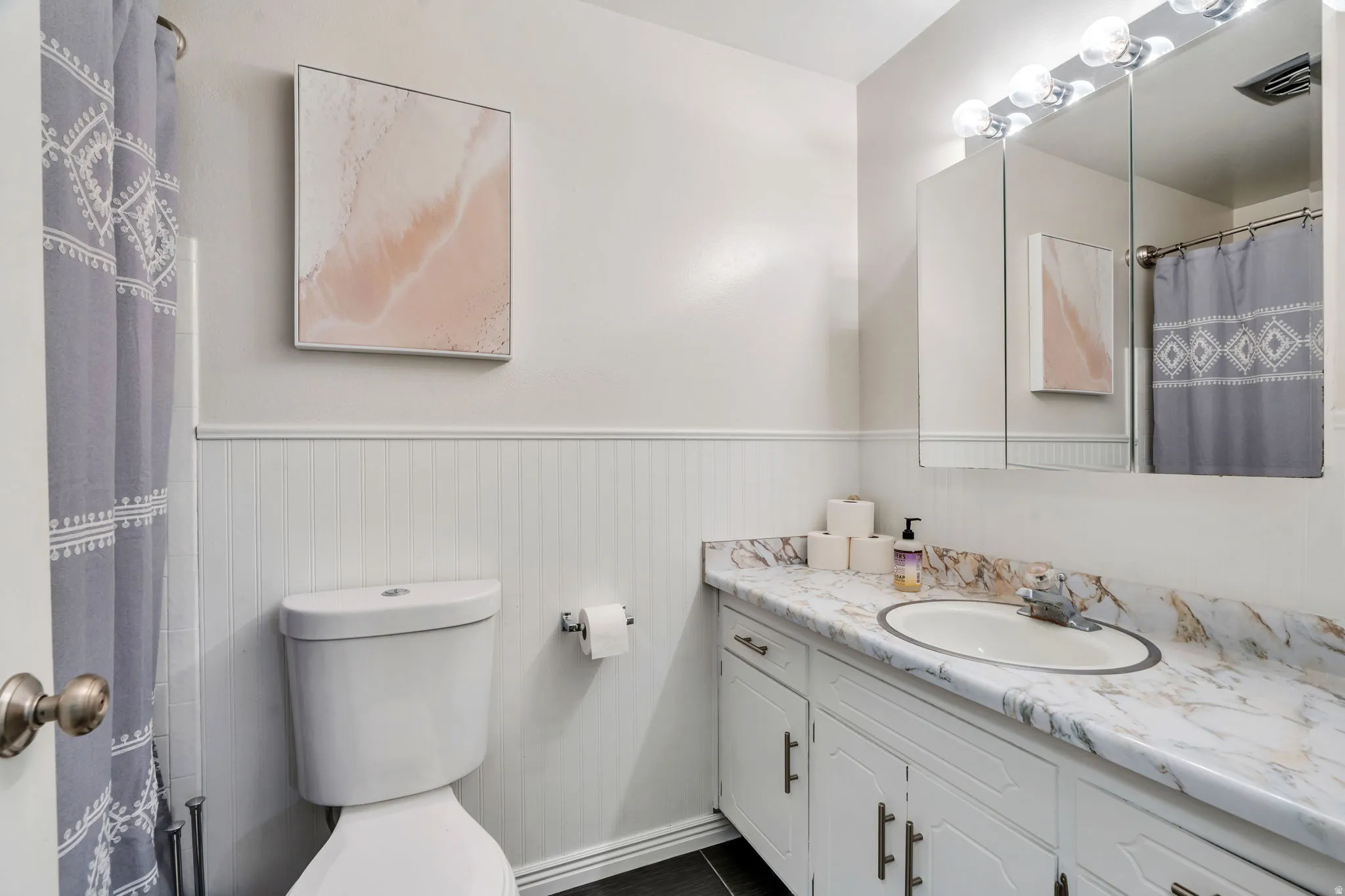 Full upstairs Bathroom featuring a white vanity with light colored countertop, upper wall-mount mirrored cabinetry and vanity light fixture