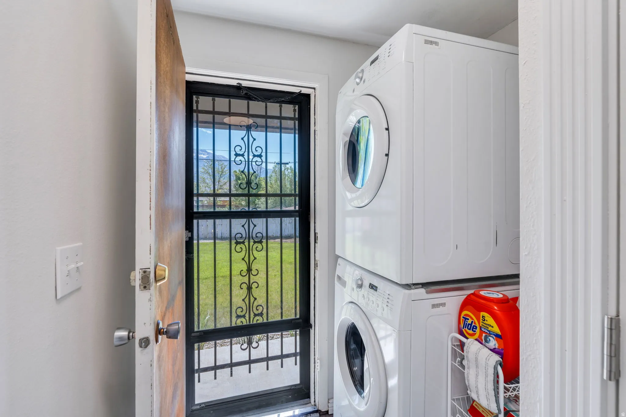 Backdoor with a screen door storm door, and a stacked white washer and dryer unit