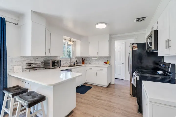 Kitchen featuring white cabinetry, light-toned wood-finish flooring, white countertops