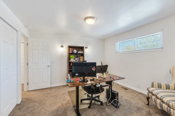 Bedroom # / Office, carpeted room with horizontal window with blinds, sconce lighting and a ceiling-mounted light fixture