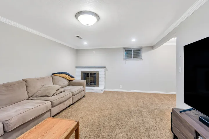Spacious room featuring neutral paint, crown molding, and carpeting flooring