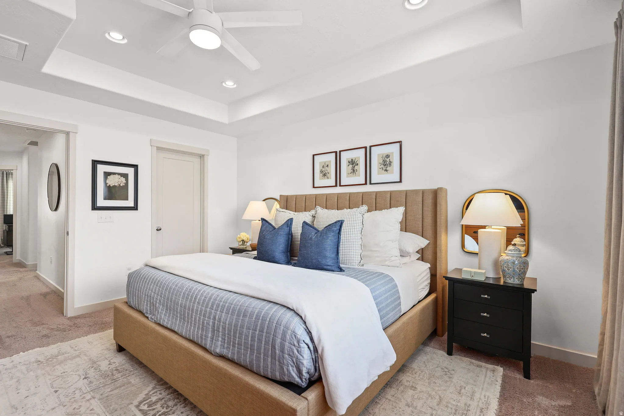 Spacious bedroom featuring a tray ceiling with recessed lighting and a ceiling fan, a neutral color palette, and carpeted flooring