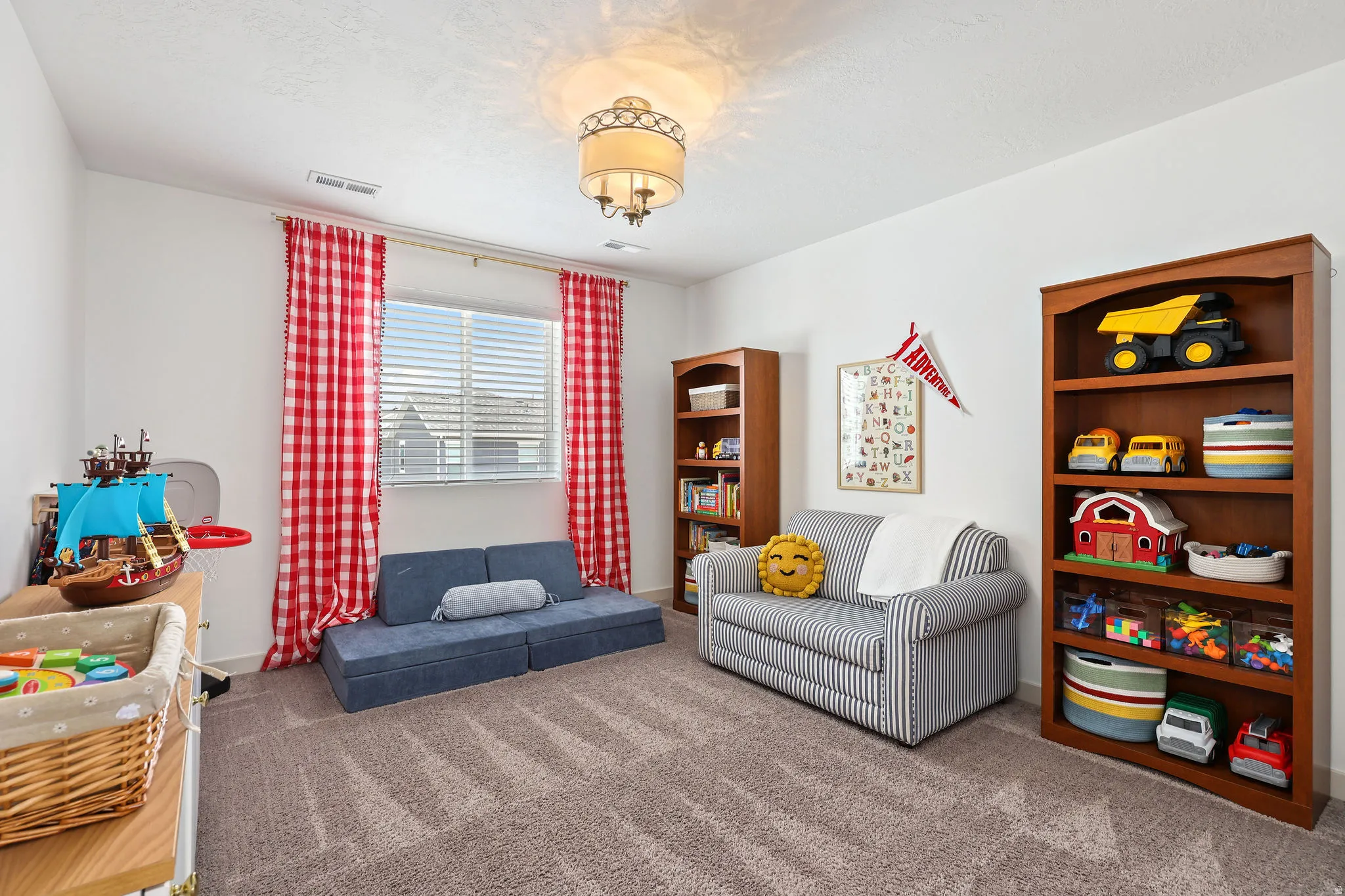 Spacious room featuring neutral carpet flooring, white walls, and a central ceiling light fixture