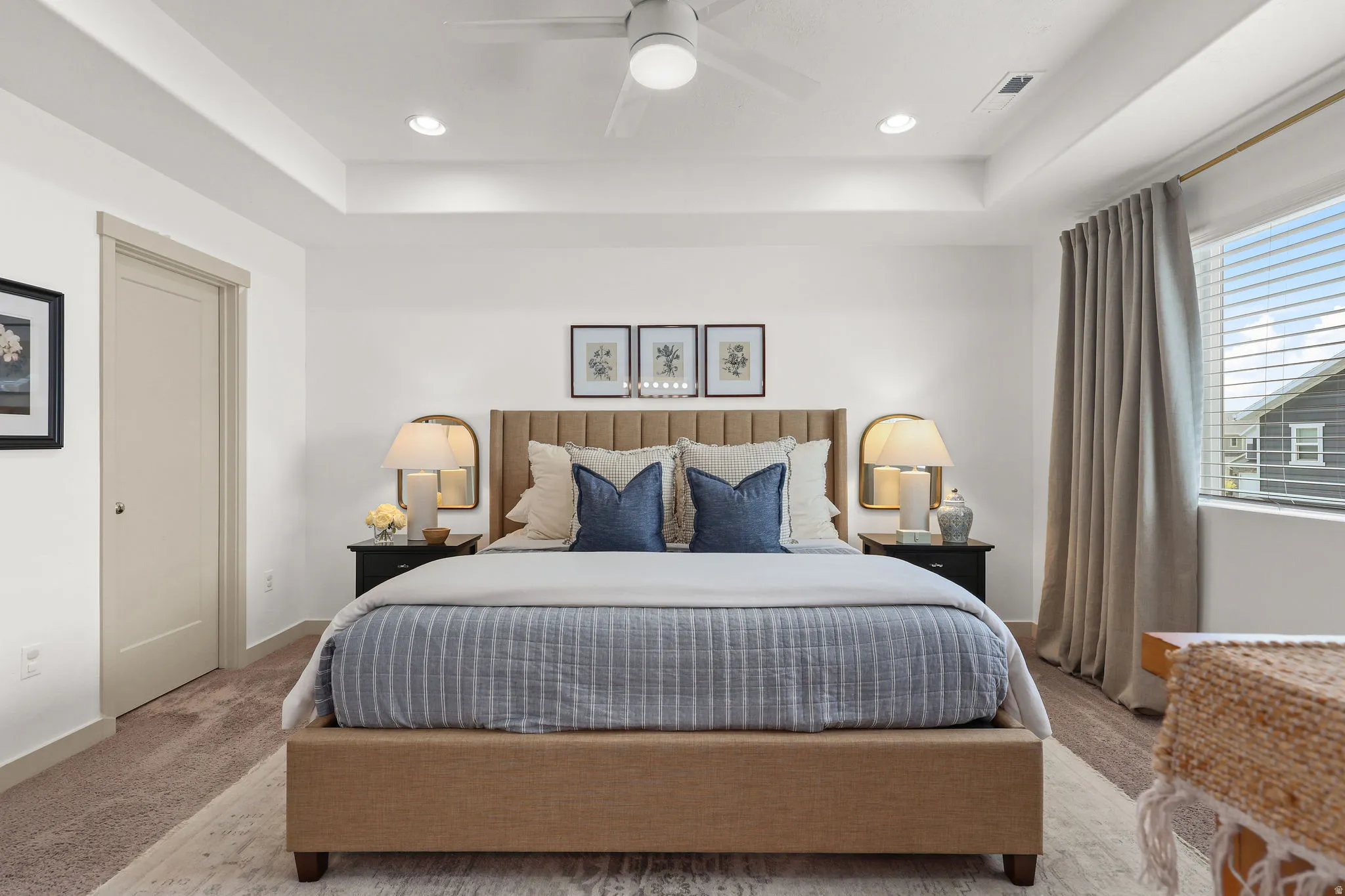 Spacious bedroom featuring a tray ceiling with recessed lighting, a ceiling fan, and carpeted flooring