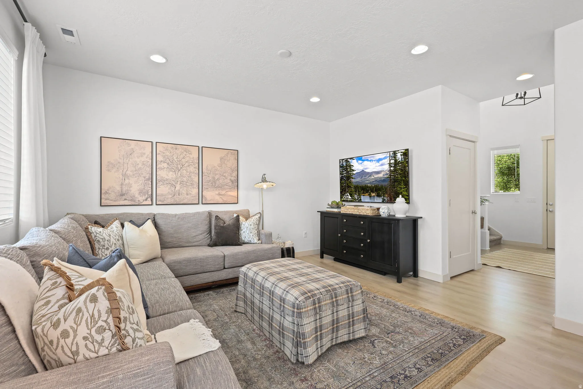 Living area featuring wood-finish flooring, recessed lighting, and a window with blinds