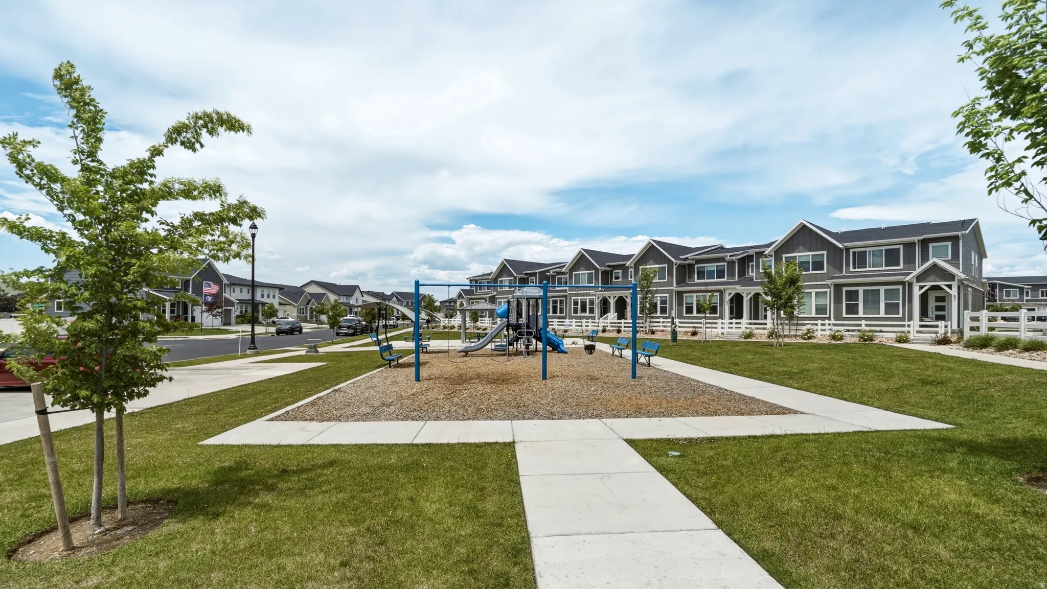 Community playground featuring a swing set and slide structure