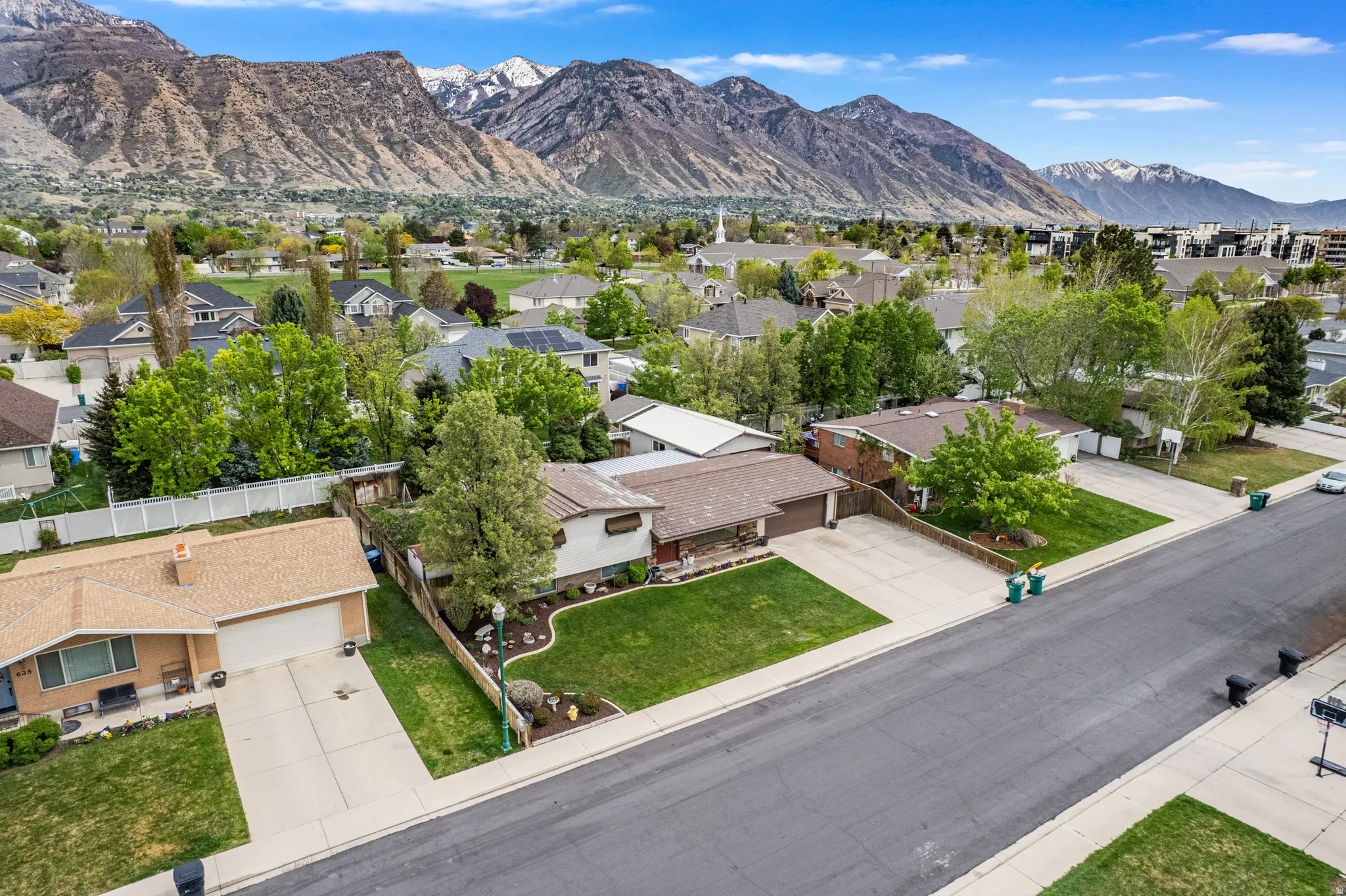 Residential area featuring multiple single-story properties with mature landscaping and mountain scenery
