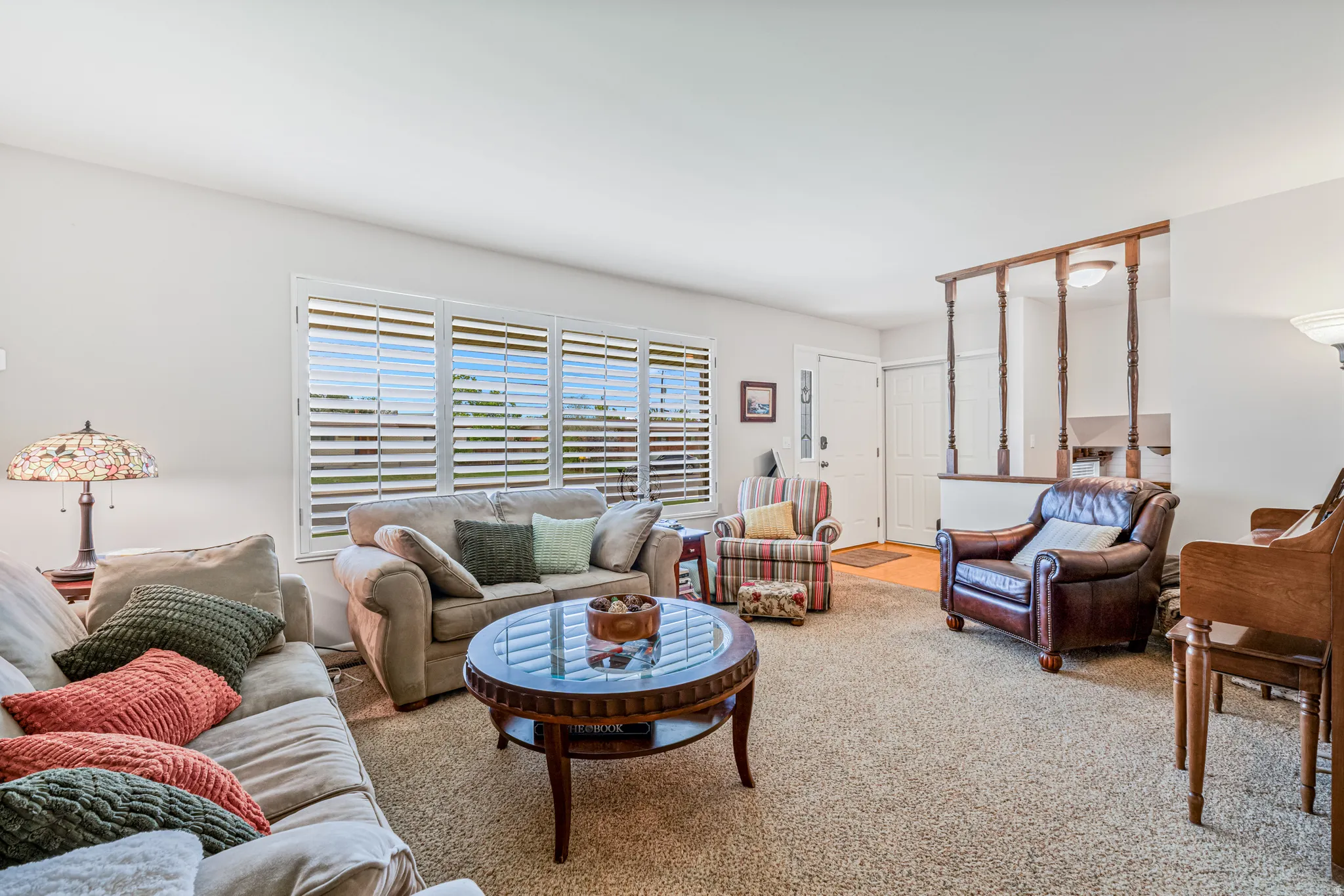 Spacious living area featuring neutral carpeting and light-toned walls