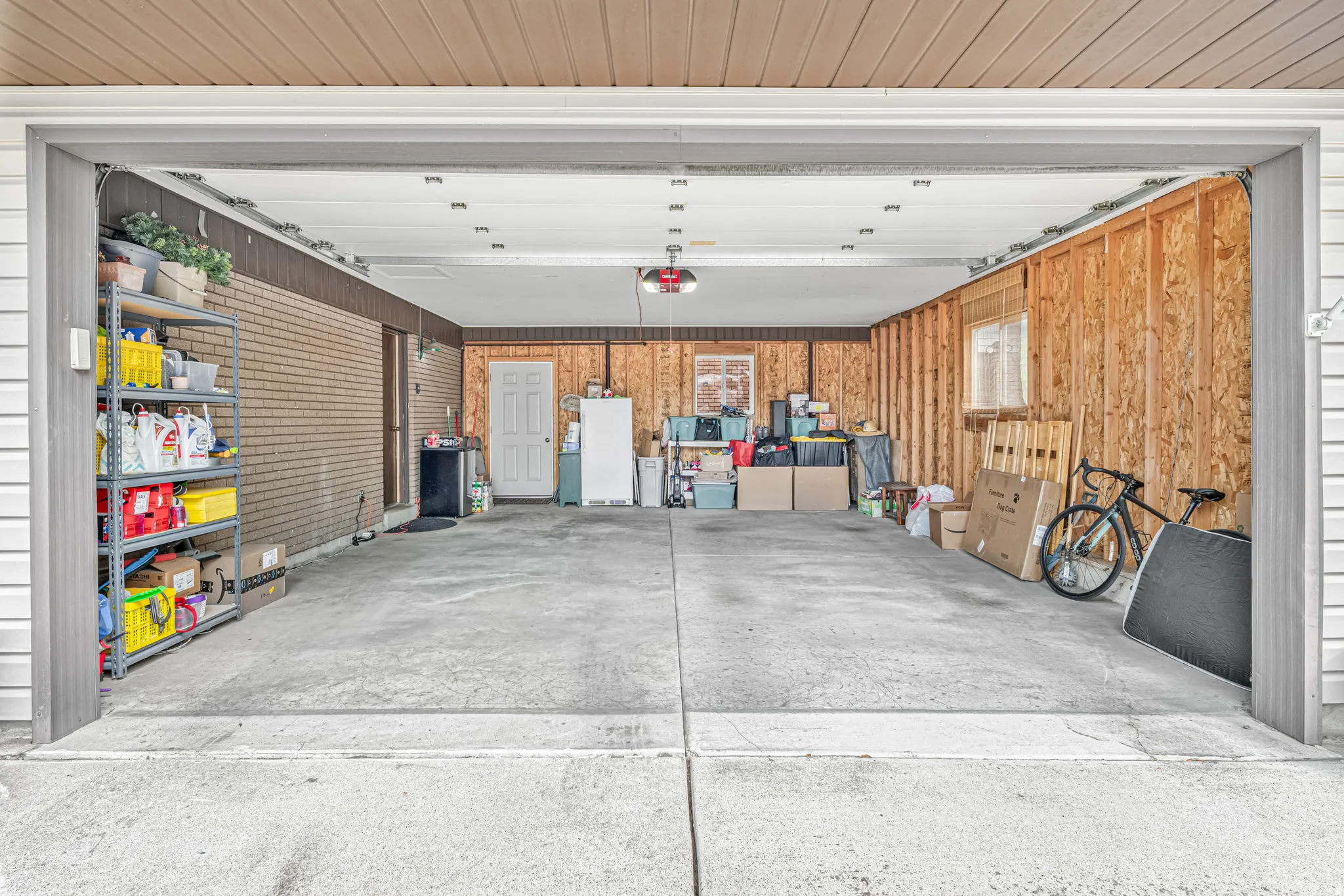 Spacious two-car garage with a concrete floor and white paneled overhead door