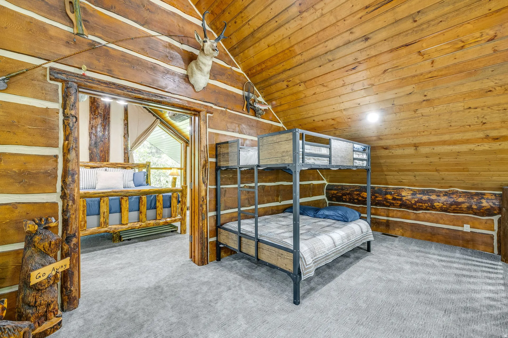 Natural wood-paneled walls and ceiling, featuring a bunk bed with metal frame construction